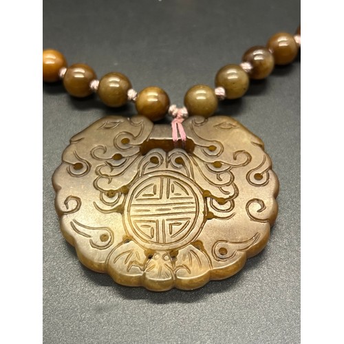 140 - Brown jade beaded hand knotted necklace with pendant & silver stamped clasp. 104g 25.5