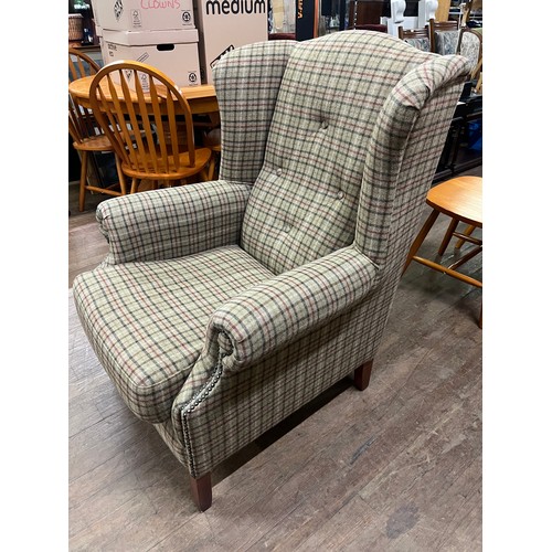 13 - Upholstered wing back armchair in tartan design with stud detailing.
