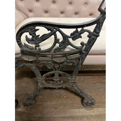 151 - Pair of antique heavy cast iron bench ends with supporting bar.