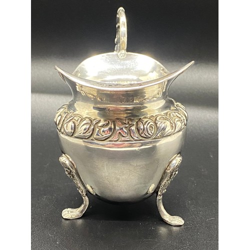 6 - silver hallmarked cream jug with scroll handle & fruit design on possibly lion feet 110 grams