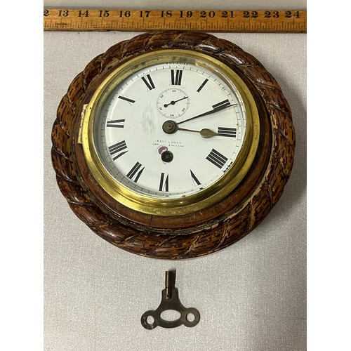 82 - Antique bulk head clock; Reid and Sons of New York. Fitted within an oak rope carved wooden body. In... 