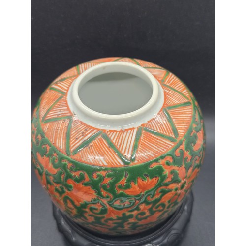 286 - Chinese green-ground enamelled lidded ginger jar upon a craved hardwood base.  Jar marked to base. 7... 