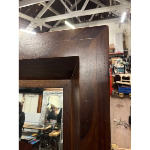 99 - Extremely large wood framed mirror on wooden stand.