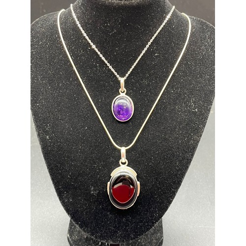 66 - 2 silver 925 oval pendants and chains to include amethyst and Whitby jet colour stones.