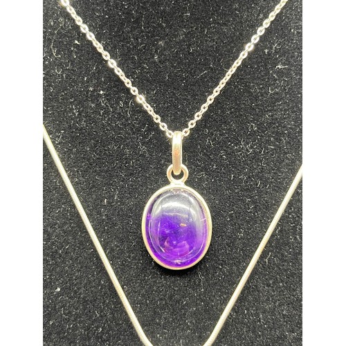 66 - 2 silver 925 oval pendants and chains to include amethyst and Whitby jet colour stones.