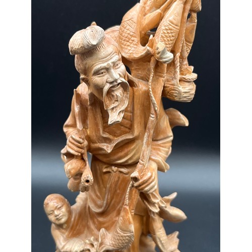 97 - 2 Japanese carved wood okimonos to include fisherman holding his catch and buddha tallest 10