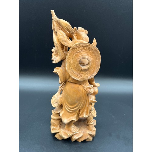 97 - 2 Japanese carved wood okimonos to include fisherman holding his catch and buddha tallest 10