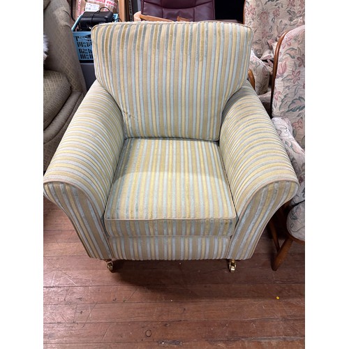 341 - Upholstered striped armchair with metal castor feet from sterling warehouse.