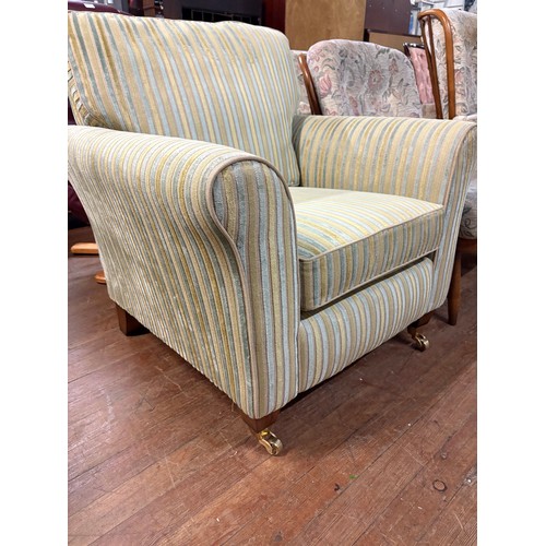 341 - Upholstered striped armchair with metal castor feet from sterling warehouse.