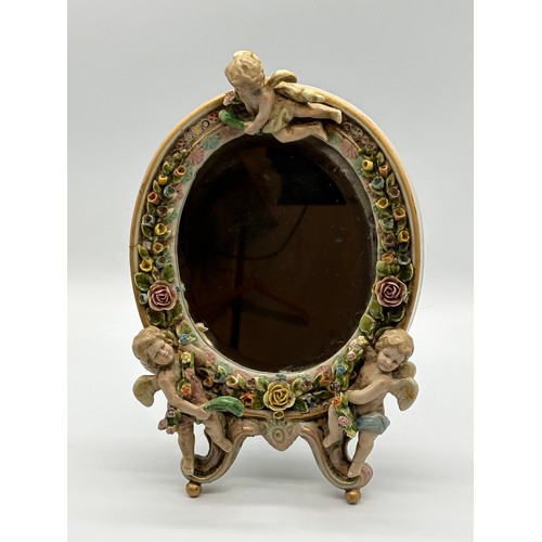 102 - An antique Sitzendorf ceramic cherub mirror, 12