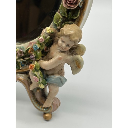 102 - An antique Sitzendorf ceramic cherub mirror, 12