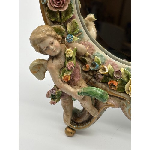 102 - An antique Sitzendorf ceramic cherub mirror, 12