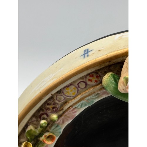 102 - An antique Sitzendorf ceramic cherub mirror, 12