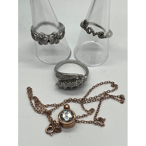 76 - Silver rose gold tone chain and pendant necklace along with silver love ring and silver daisy ring a... 