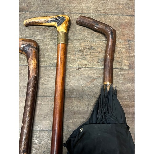 130C - 3 antique walking sticks/canes and one umbrella.