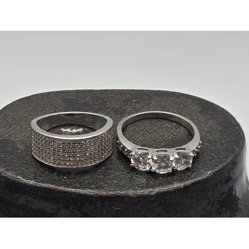 24 - 2 silver rings to include eternity band paved with cubic zirconia.