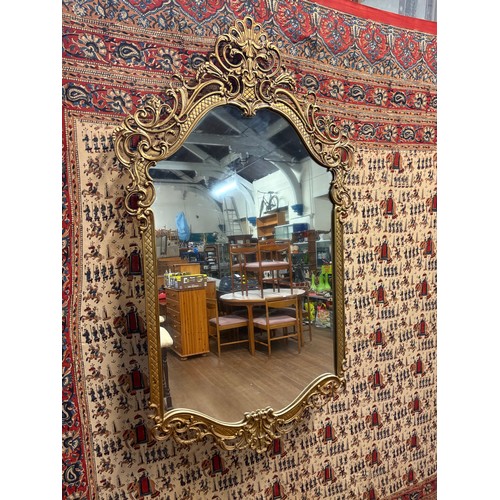 A large metal ornate gold toned baroque or rococo style decorative wall ...