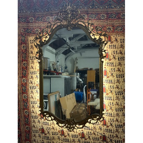 A large metal ornate gold toned baroque or rococo style decorative wall ...
