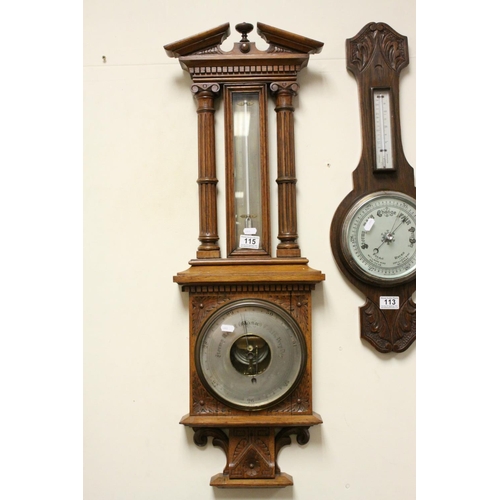 115 - Antique oak carved Aneroid barometer and thermometer  with reeded below a proscenium arch.