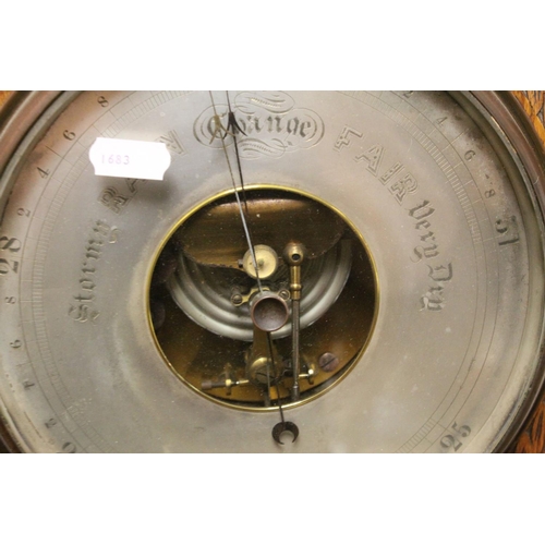115 - Antique oak carved Aneroid barometer and thermometer  with reeded below a proscenium arch.