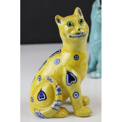 28 - In the manner of Galle, A Mosanic Pottery Seated Cat, glazed in yellow with blue painted hearts and ... 