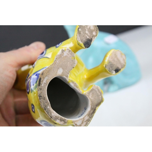 28 - In the manner of Galle, A Mosanic Pottery Seated Cat, glazed in yellow with blue painted hearts and ... 