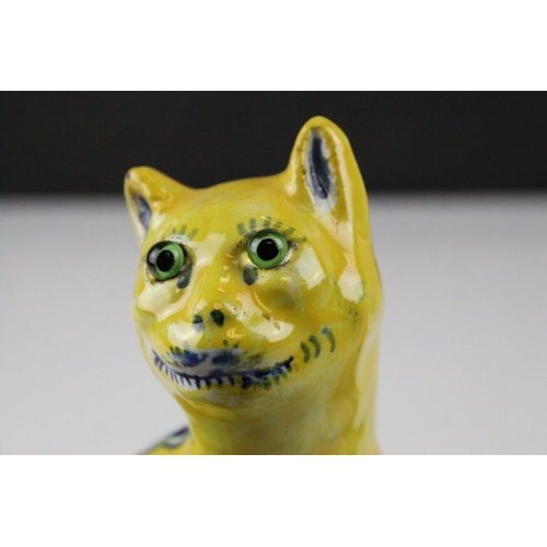 28 - In the manner of Galle, A Mosanic Pottery Seated Cat, glazed in yellow with blue painted hearts and ... 