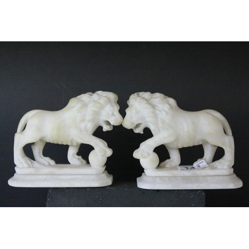 141 - Pair of Carved Alabaster Lions holding a Ball under their front paw, 15cms long