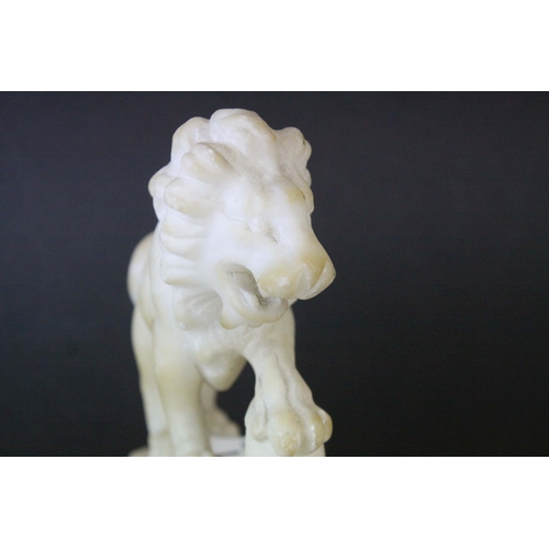 141 - Pair of Carved Alabaster Lions holding a Ball under their front paw, 15cms long