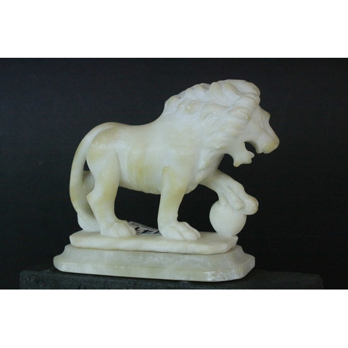 141 - Pair of Carved Alabaster Lions holding a Ball under their front paw, 15cms long