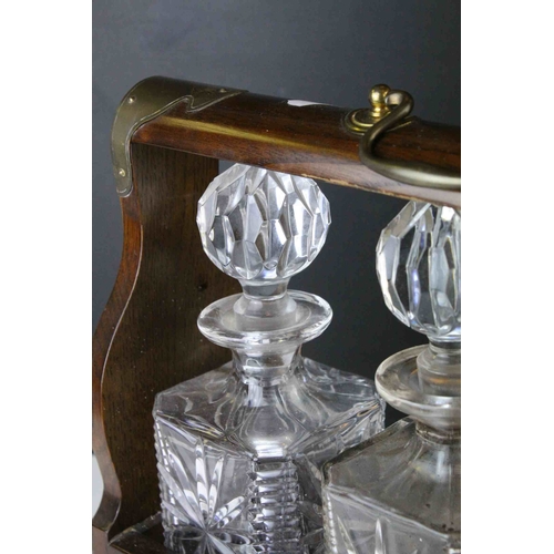 150 - Oak and Brass Mounted Tantalus with three matching decanters, with key, 34cms wide x 29.5cms high