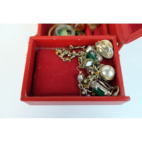 203 - Costume Jewllery including earrings, bracelets in a cantilevered red leather jewellery case