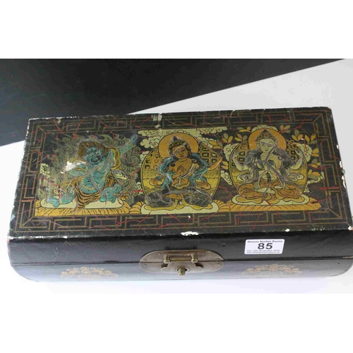 85 - Oriental Black Lacquered Box with Brass Clasps and Handles, the lid decorated with Three Seated Deit... 