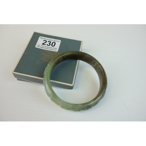 230 - Spinach Jade Bangle with carved design to outer rim, 9cms diameter