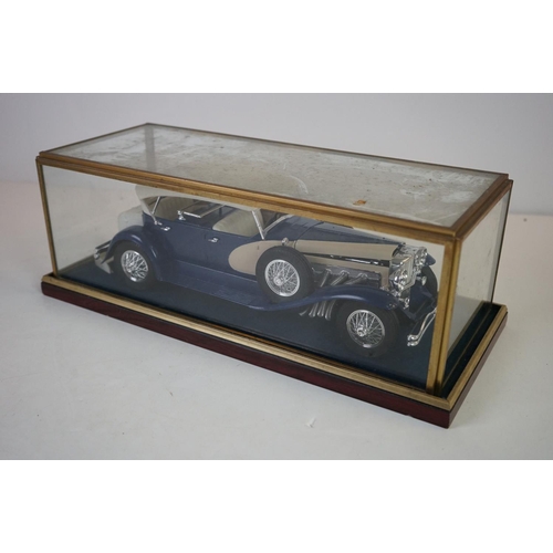 1169 - Five cased 1:18 scale diecast model classic cars to include BMW, Jaguar etc, models fixed to a woode... 