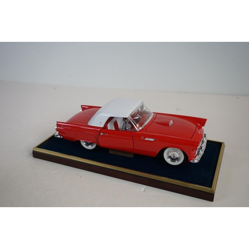 1169 - Five cased 1:18 scale diecast model classic cars to include BMW, Jaguar etc, models fixed to a woode... 