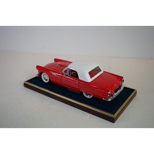 1169 - Five cased 1:18 scale diecast model classic cars to include BMW, Jaguar etc, models fixed to a woode... 