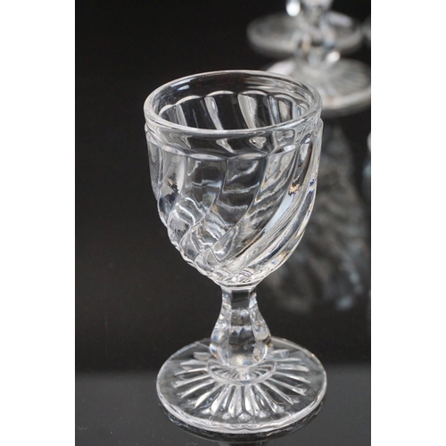 146 - Part suite of moulded and cut glass port and wine glasses, the bowls with spiral decoration (nine wi... 