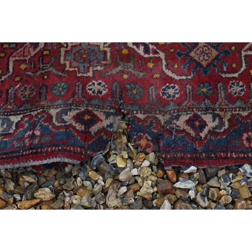 889 - Eastern Wool Red Ground Rug with stylised pattern, 330cms x 170cms