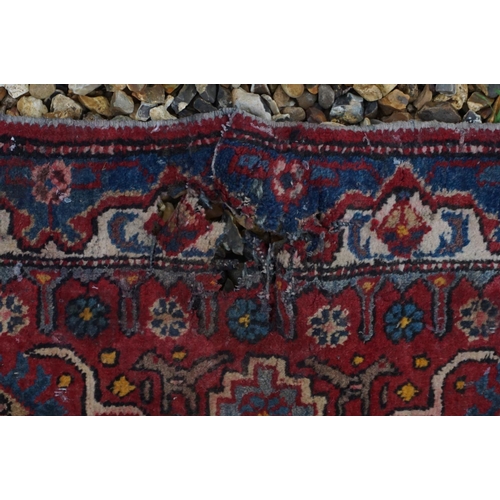 889 - Eastern Wool Red Ground Rug with stylised pattern, 330cms x 170cms