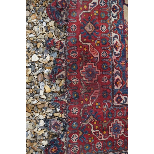 889 - Eastern Wool Red Ground Rug with stylised pattern, 330cms x 170cms