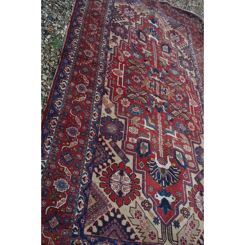 889 - Eastern Wool Red Ground Rug with stylised pattern, 330cms x 170cms