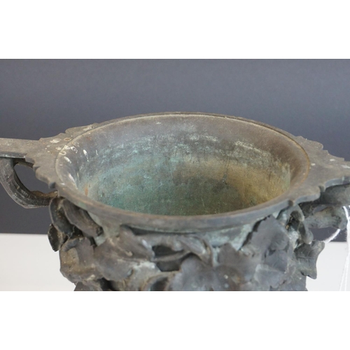 115 - A 19th century bronze two handled cup profusely decorated with grape vines mounted on a stone base p... 