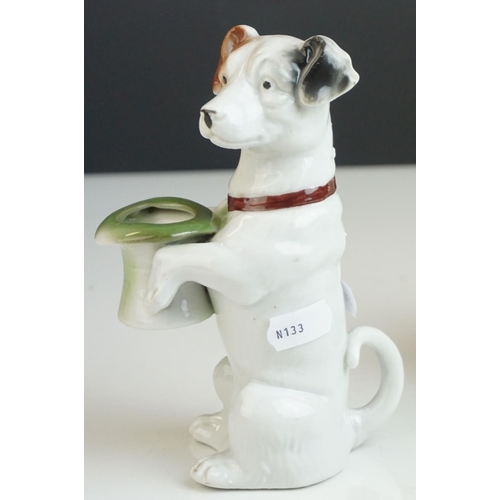 163 - A green Sylvac style dog, a ceramic terrier holding a hat and a Rushton Pottery Isle of Mann Manx ca... 