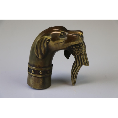 167 - A walking stick handle in the form of a gundog with gamebird in its mouth.