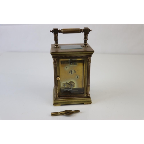 186 - A French made brass carriage clock with white enamel dial, complete with key.