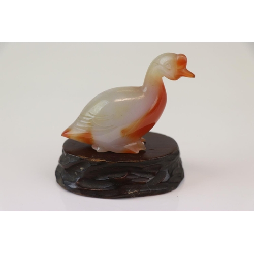 199 - A small carved jade duck on wooden base.