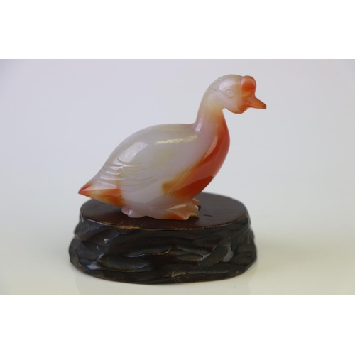 199 - A small carved jade duck on wooden base.