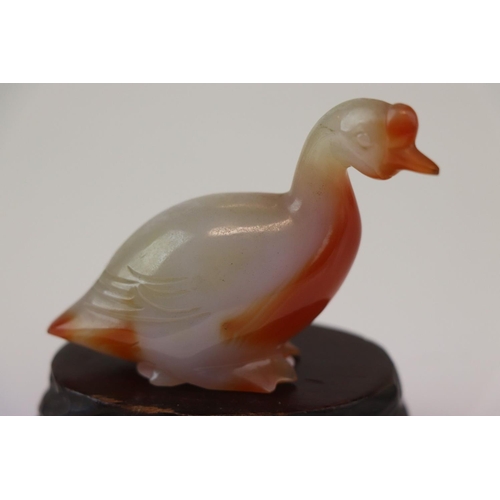 199 - A small carved jade duck on wooden base.