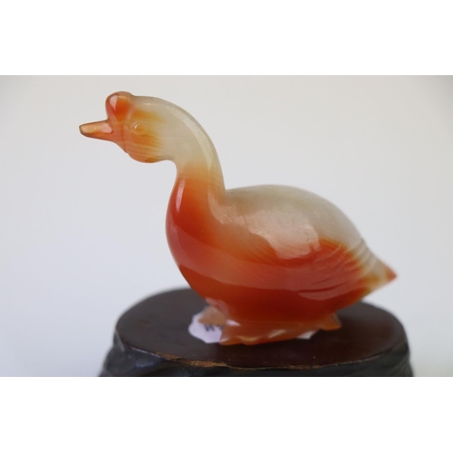 199 - A small carved jade duck on wooden base.